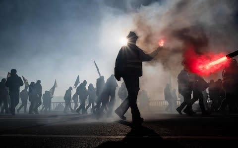 People light flares during a demonstration on December 10, 2019 in Lyon  - Credit: &nbsp;JEFF PACHOUD/AFP