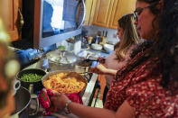 HOLD FOR ENRIC MARTI Vivian Zayas cooks rice and beans by her mother's recipe, the recently deceased Ana Martinez, as she and her sister Alexa prepare Thanksgiving dinner, Thursday, Nov. 26, 2020, in Deer Park, N.Y. (AP Photo/John Minchillo)