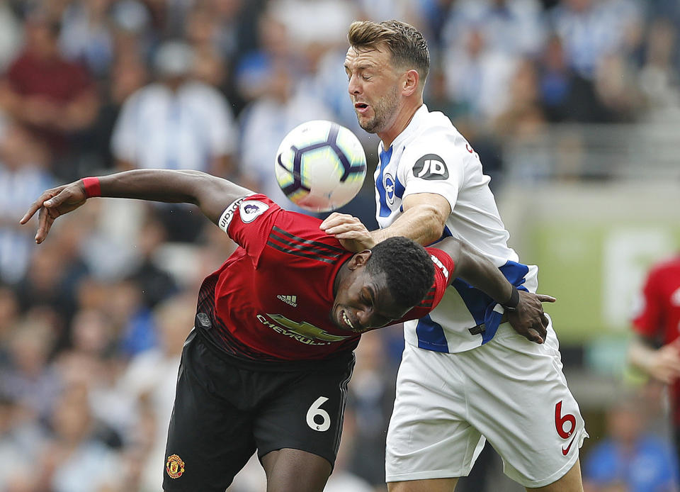 Manchester United's Paul Pogba, left, and Brighton's Dale Stephens battle for the ball during the English Premier League soccer match between Brighton and Hove Albion and Manchester United at the Amex stadium in Brighton, England, Sunday, Aug.19, 2018. (AP Photo/Alastair Grant)