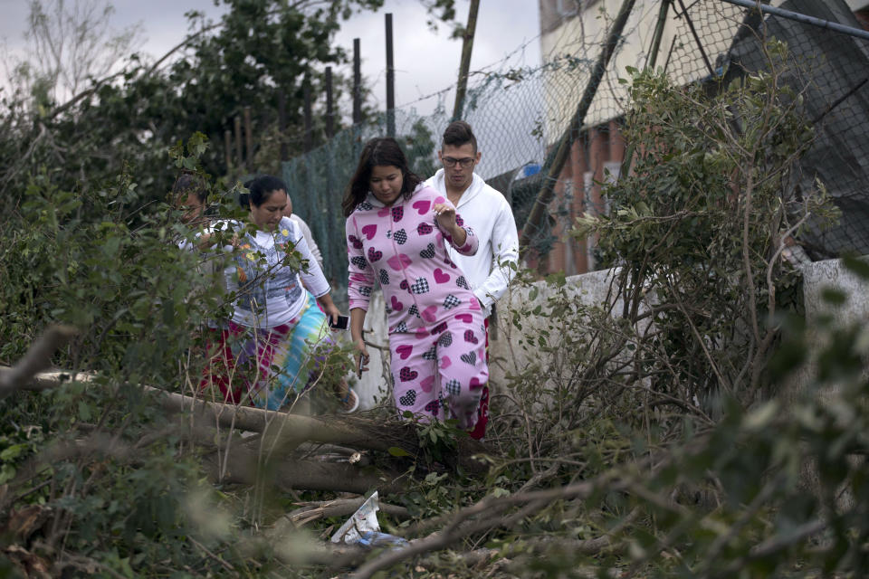 People walk over debris in the street after a tornado in Havana, Cuba, Monday, Jan. 28, 2019. A tornado and pounding rains smashed into the eastern part of Cuba’s capital overnight, toppling trees, bending power poles and flinging shards of metal roofing through the air as the storm cut a path of destruction across eastern Havana. (AP Photo/Ramon Espinosa)