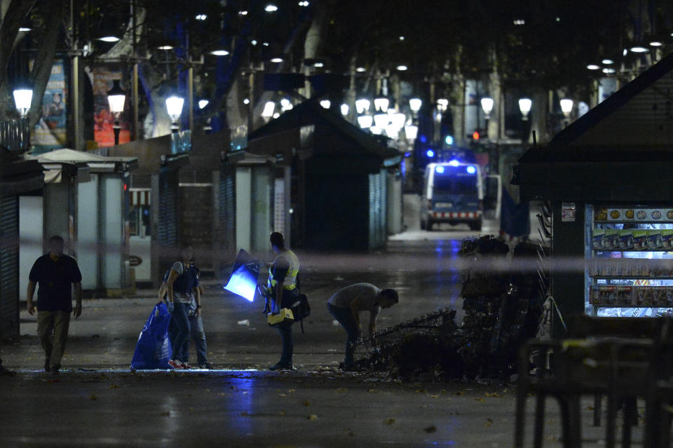 Policemen check the area after towing away the van.&nbsp;