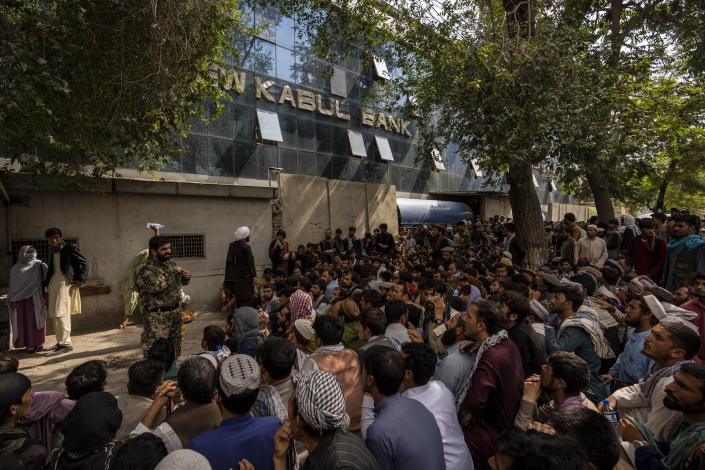 Afghans wait in front of a bank as they try to withdraw money in Kabul, Afghanistan, Sunday, Sept. 12, 2021. (AP Photo/Bernat Armangue)