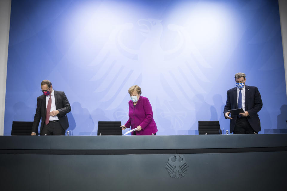 German Chancellor Angela Merkel, center, Bavaria's Governor Markus Soeder, right, and Berlin's mayor Michael Mueller arrive for a press conference after a meeting of the governors of the German states and Chancellor Merkel in Berlin Germany, Wednesday, Oct. 14, 2020. (Stefanie Loos/Pool Photo via AP)