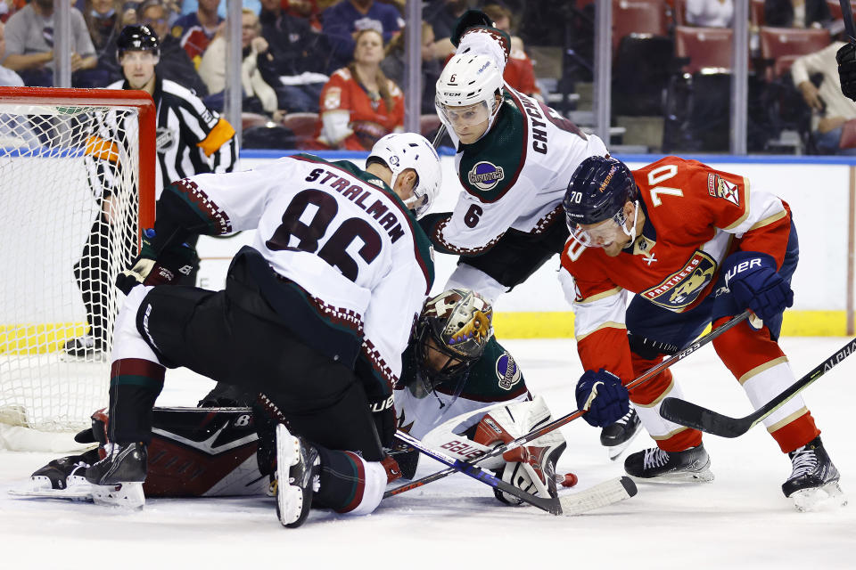 Arizona Coyotes goaltender Karel Vejmelka, bottom center, saves a shot on goal by Florida Panthers right wing Patric Hornqvist (70) during the second period of an NHL hockey game, Monday, Oct. 25, 2021, in Sunrise, Fla. (AP Photo/Michael Reaves)