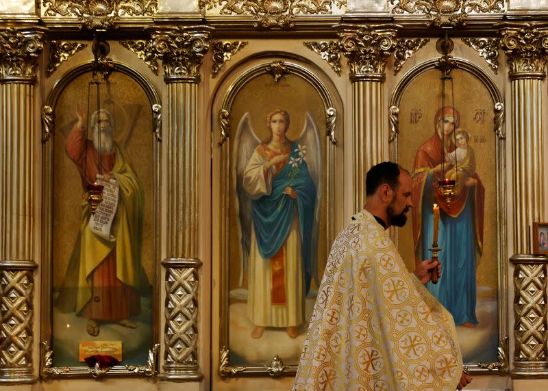 Parish priest Andriy Klyushev conducts a service in Irpin