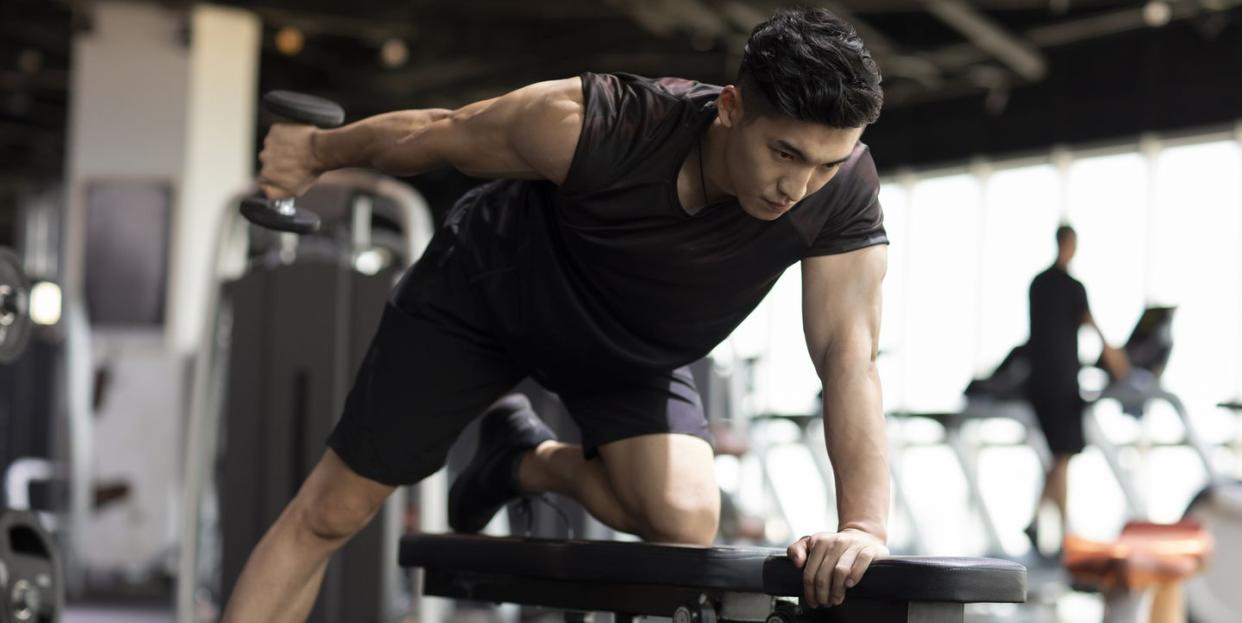 young man working out with dumbbell at gym