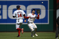 Washington Nationals center fielder Jacob Young, right, makes a catch on a drive by Philadelphia Phillies' Whit Merrifield for the out during the fifth inning of a baseball game, Sunday, April 7, 2024, in Washington. Nationals' Ildemaro Vargas is at left. (AP Photo/Nick Wass)