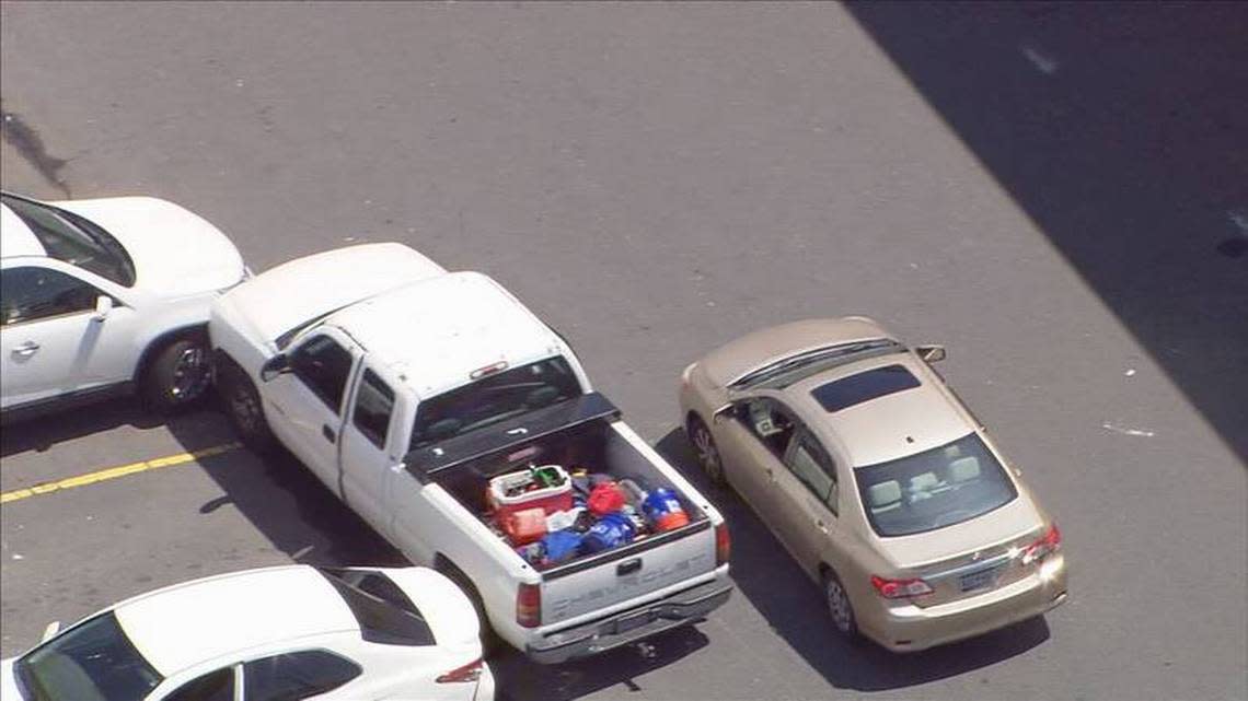 This image from WSOC’s helicopter shows a sedan alongside a pickup truck in the parking lot of a Walmart in southwest Charlotte on Wednesday, July 6, 2022. The driver of the pickup truck was seen stealing the sedan then heading on an erratic drive onto highways and city streets.