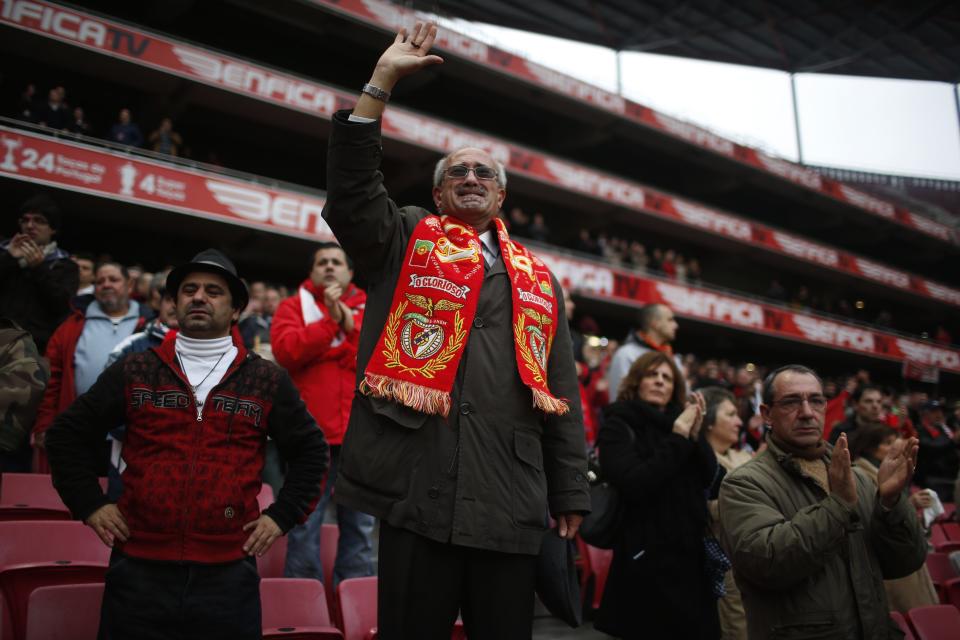 A supporter waves goodbye as the funeral car containing Eusebio's coffin leaves the Luz stadium in Lisbon January 6, 2014.