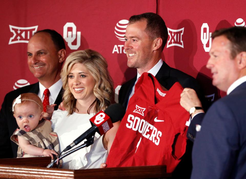 Lincoln Riley (with jersey) is announced as OU football head coach on June 7, 2017, at a press conference at Gaylord Family-Oklahoma Memorial Stadium in Norman. Beside him are his wife Caitlin and daughter Stella, athletic director Joe Castiglione (left) and former coach Bob Stoops (right).