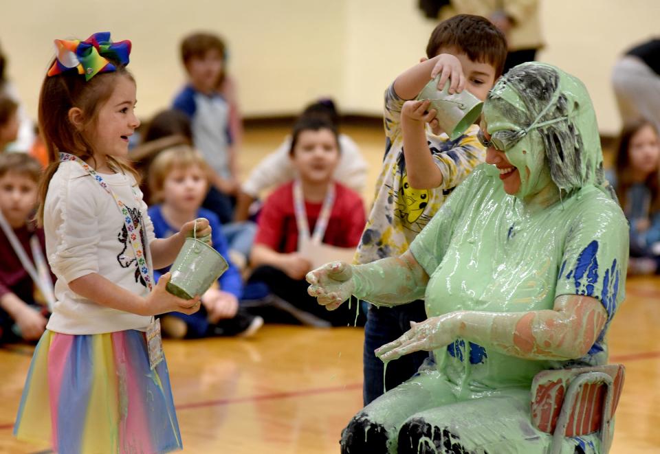 McKenzie Carter, a Young 5's student at Sodt Elementary, smiles at Principal Tara Roe after she and kindergartner Ryan Vallade were the last two students to dump slime onto her.