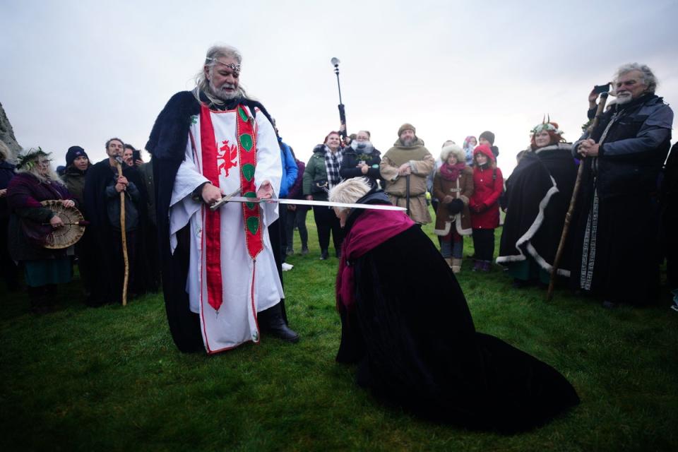 A self-proclaimed incarnation of King Arthur, Arthur Pendragon, knights his followers at Stonehenge (PA)