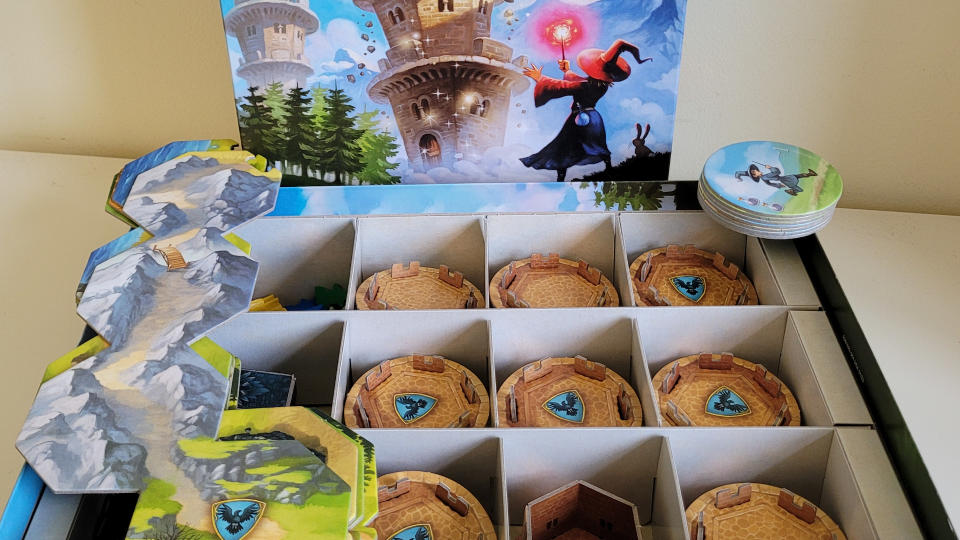 An open Wandering Towers box, with board tiles and tokens sitting on the top