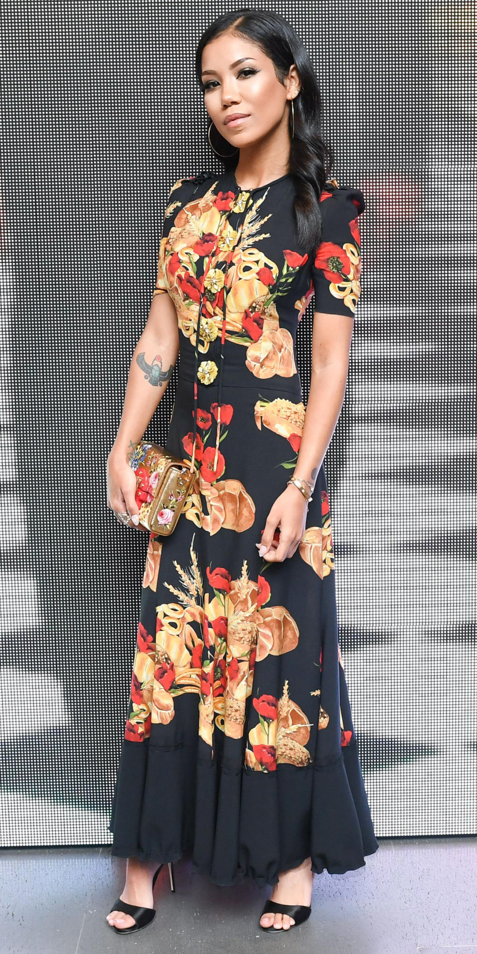 <p>Jhene Aiko was a true stunner at the Dolce & Gabbana New Vision and Millennials Party in this floral dress with ornate brooch detailing. She kept the look romantic with black satin sandals, gold jewelry, and a floral clutch to match.</p>