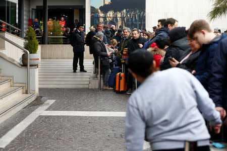 Passengers who were evacuated due to a fire at Ciampino Airport in Rome, Italy, February 19, 2019 gather outside the teminal building. REUTERS/Yara Nardi