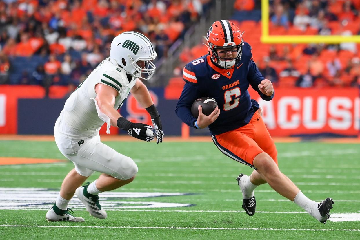 Syracuse Orange quarterback Kyle McCord runs the ball against Ohio Bobcats defensive end Ben McNaboe during the first half at the JMA Wireless Dome.