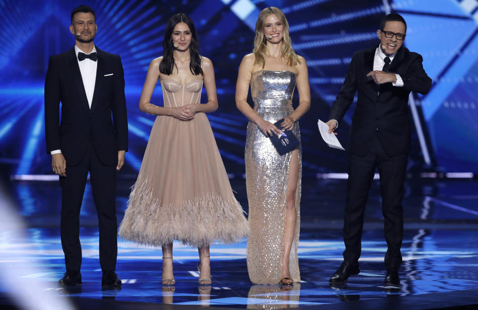 Eurovision hosts from left, Assi Azar, Lucy Ayoub, Bar Refaeli, and Erez Tal walk onto the stage for the start of the 2019 Eurovision Song Contest grand final in Tel Aviv, Israel, Saturday, May 18, 2019. (AP Photo/Sebastian Scheiner)