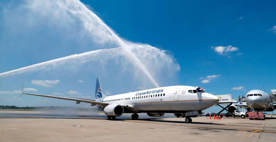 The flight crew of the inaugural Copa Airlines flight from Panama City, Panama to Raleigh-Durham International Airport wave the Panamanian and American flags as they get a water cannon salute as they arrive at their gate Friday, June 21, 2024.