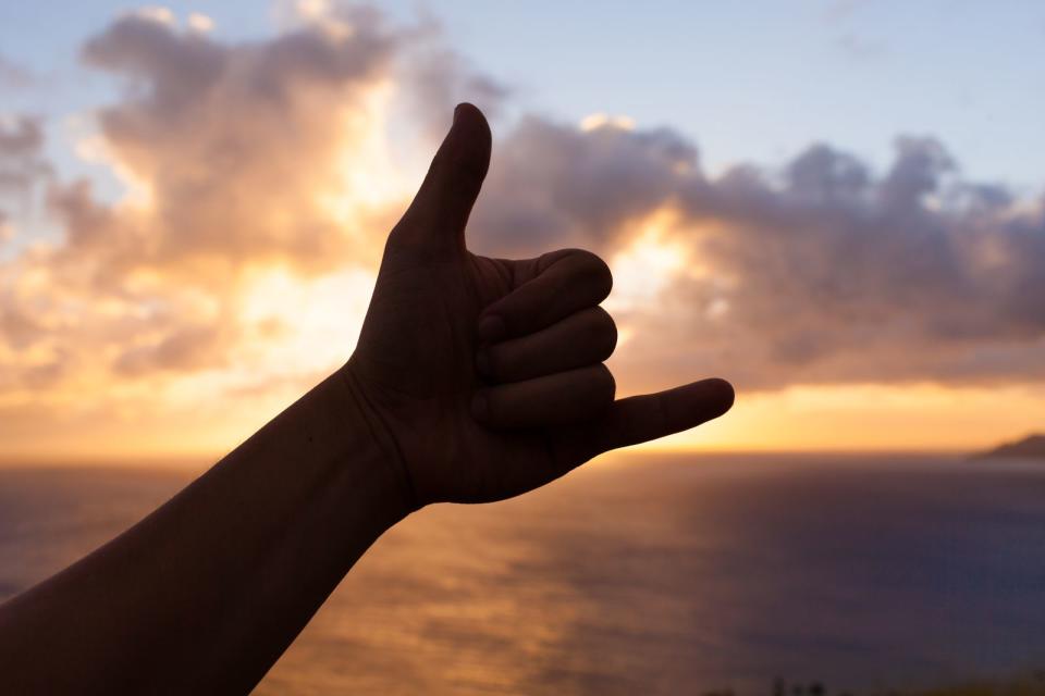 Die Hand mit ausgestrecktem Daumen und kleinem Finger bei ansonsten geschlossener Faust symbolisiert angeblich eine Hängematte. Die auf Hawaii gebräuchliche Geste namens "Shaka" ist Ausdruck absoluter Lässigkeit. Dank der Surfer hat sich diese Art zu winken und "alles in Ordnung" anzudeuten über die Inselkette hinaus verbreitet. (Bild: iStock/kieferpix)