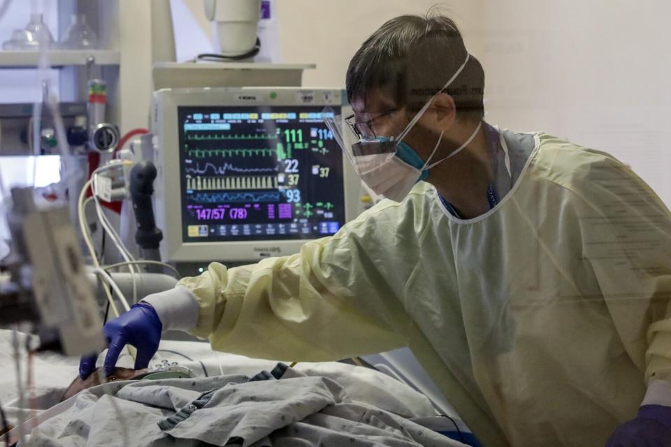 Dr. David Wong checks a COVID patient at Arrowhead Regional Medical Center.