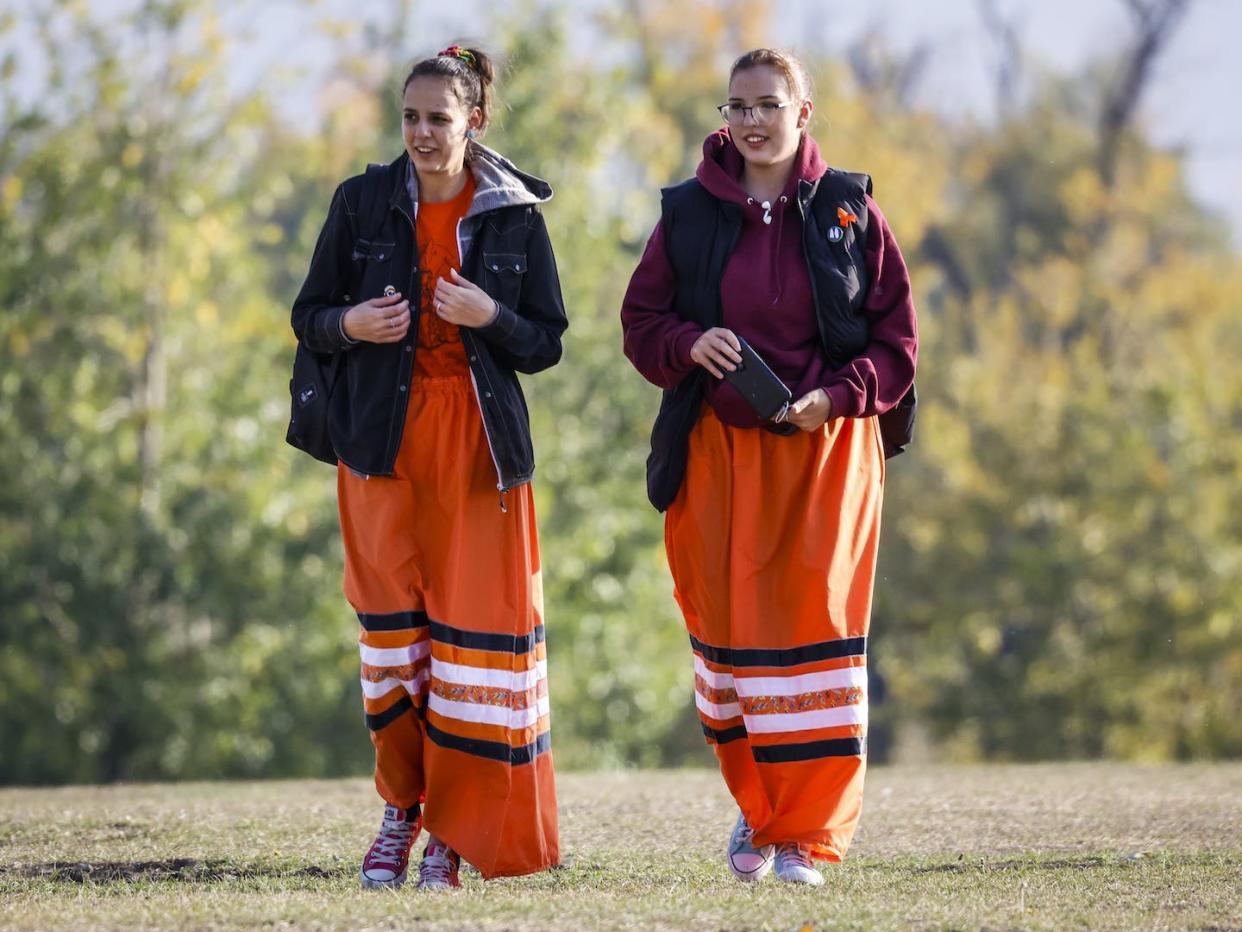 Language is so important, says prof. Frank Deer. Generational knowledge of culture is passed through stories, language, and symbols. Here two young women wearing ribbon skirts arrive for 2022 National Day for Truth and Reconciliation ceremonies in Calgary, Alta. (CP/Jeff McIntosh)