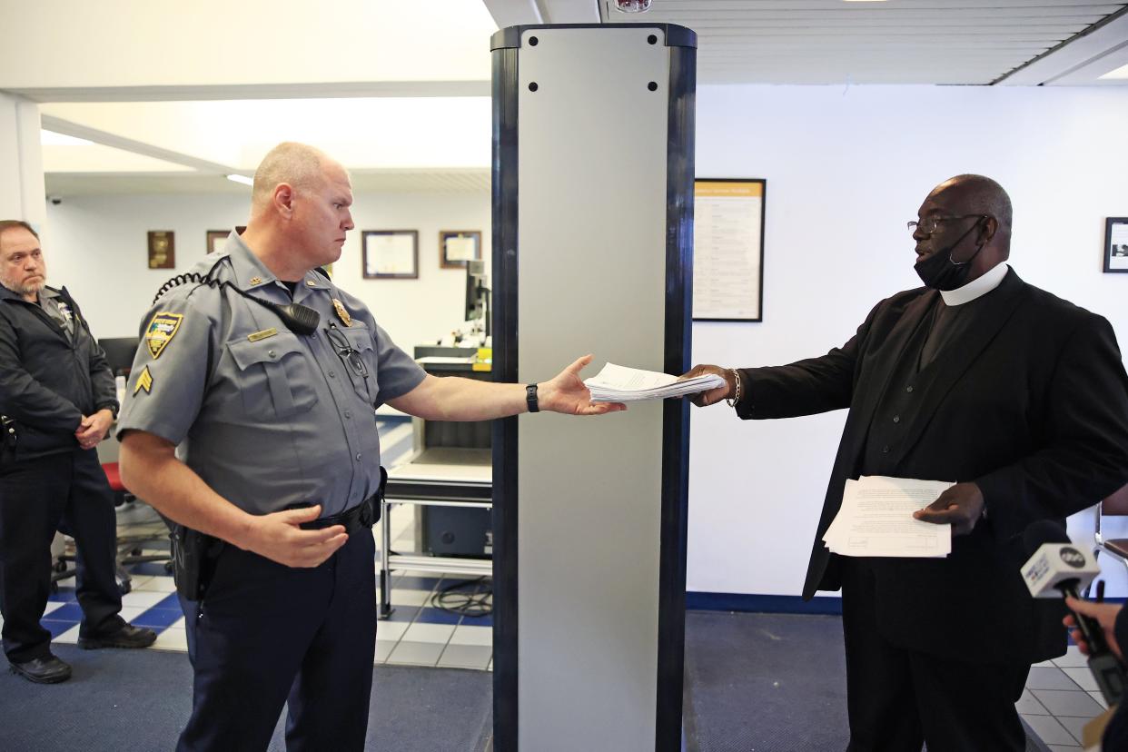 Jacksonville's ICARE program tried to schedule a sit-down meeting and deliver a written statement to Sheriff Mike Williams. When told the sheriff was not in and failing to get his aide by phone, the Rev. Tan Moss (right), co-president of ICARE, presented Sgt. Mark Mason with letters of support for an adult civil citation program.