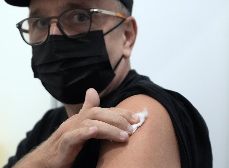 Vitaly Pavlov from Rostov-on-Don rests after a vaccination at Belgrade Fair makeshift vaccination center in Belgrade, Serbia, Saturday, Oct. 2, 2021. Pavlov looked for a vaccine that would allow his family to travel freely — a quest that brought them to Serbia, where hundreds of Russian citizens have flocked in recent weeks to receive Western-approved COVID-19 shots. (AP Photo/Darko Vojinovic)