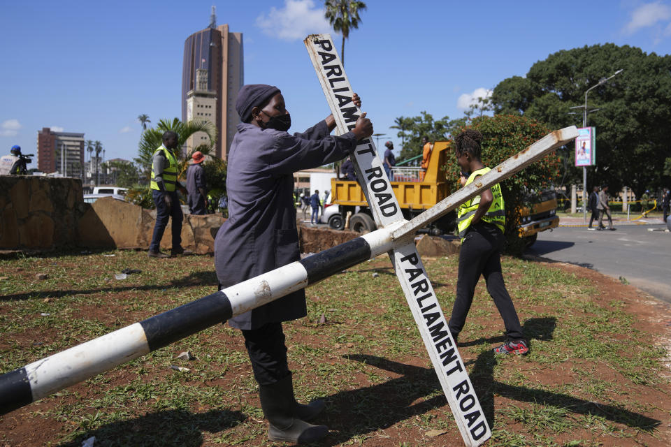 Operarios municipales de Nairobi reparan una señal tras las manifestaciones en una calle en el centro de Nairobi, Kenia, el 26 de junio de 2024. (AP Foto/Brian Inganga)