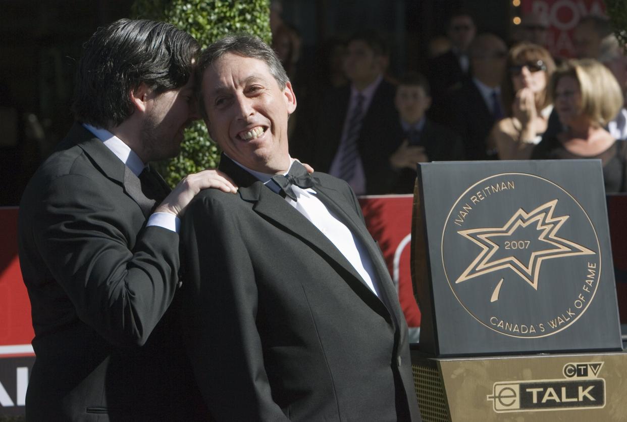 FILE - Ivan Reitman, right, shares a moment with his son Jason, left, after being inducted into the Canadian Walk of Fame in Toronto, on June 9, 2007. Ivan Reitman, the influential filmmaker and producer behind beloved comedies from “Animal House” to “Ghostbusters,” has died. Reitman passed away peacefully in his sleep Saturday night, Feb. 12, 2022, at his home in Montecito, Calif., his family told The Associated Press.  He was 75.  (Frank Gunn/The Canadian Press via AP, File)