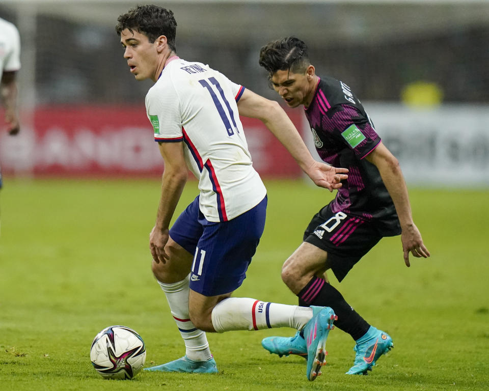 United States' Giovanni Reyna, left, dribbles the ball chased by Mexico's Gerardo Arteaga during a qualifying soccer match for the FIFA World Cup Qatar 2022 at Azteca stadium in Mexico City, Thursday, March 24, 2022. (AP Photo/Eduardo Verdugo)