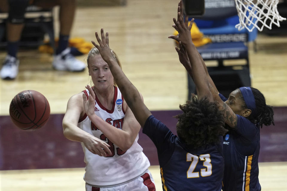 North Carolina State's Elissa Cunane (33) passes the ball past North Carolina A&T's Shayla Nelson (23) during the first half of a college basketball game in the first round of the women's NCAA tournament at the University Events Center in San Marcos, Texas, Sunday, March 21, 2021. (AP Photo/Chuck Burton)