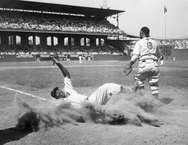 During the 12th annual East-West All-Star Game of the Negro Leagues, American baseball player Josh Gibson (1911 - 1947), of the East team, creates a cloud of dust as he slides into home plate during the fourth inning, Comiskey Park, Chicago, Illinois, August 13, 1944. West team's catcher Ted Radcliffe (1902 - 2005) is visible at right. The West defeated the East, 7-4.