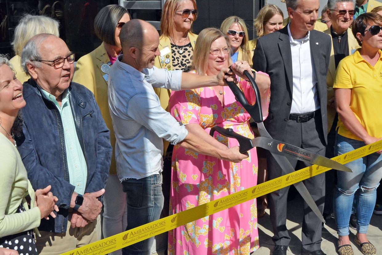 Los Angeles-based artist Pontus Willfors and Mary Wilkerson, Central Bank of Boone County vice president of marketing, prepare to cut a ribbon Friday on the newly installed sculpture 'The Conversation' at the bank's Eighth Street branch. 