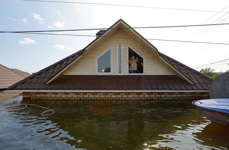 MATERIAL SENSIBLE. ESTA IMAGEN PUEDE OFENDER O MOLESTAR. Una mujer que se niega a ser evacuada de una casa inundada gesticula hacia los rescatadores tras el colapso de la presa de Nova Kajovka en el curso del conflicto entre Rusia y Ucrania, en la ciudad de Hola Prystan en la región controlada por Rusia de Jersón, Ucrania