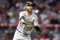 Oakland Athletics starting pitcher Paul Blackburn lobs the ball to first to get out Los Angeles Angels' Anthony Rendon on a ground ball out during the third inning of a baseball game in Anaheim, Calif., Friday, May 20, 2022. (AP Photo/Alex Gallardo)