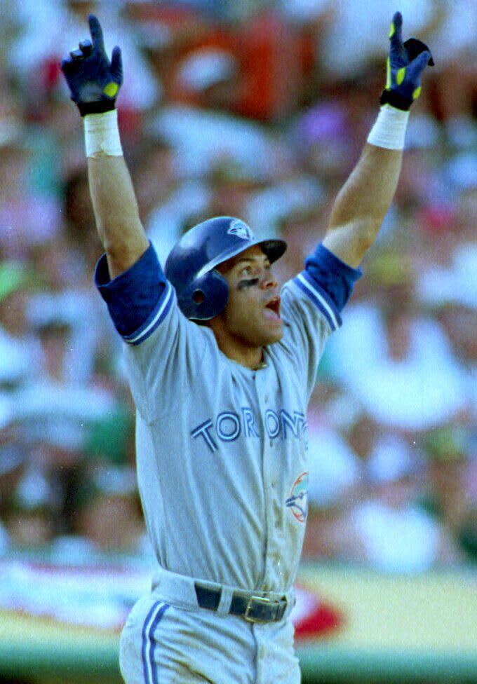 OAKLAND, :  Toronto Blue Jays Roberto Alomar raises his arms as he watches the ball he just hit off of Oakland A's Dennis Eckersley sail over the right field wall 11 October, 1992 in the ninth inning to tie the game at 6-6 in game four of the American League Championship Series in Oakland, CA. The home run was Alomar's fourth hit of the game. (Photo credit should read CHRIS WILKINS/AFP/Getty Images)