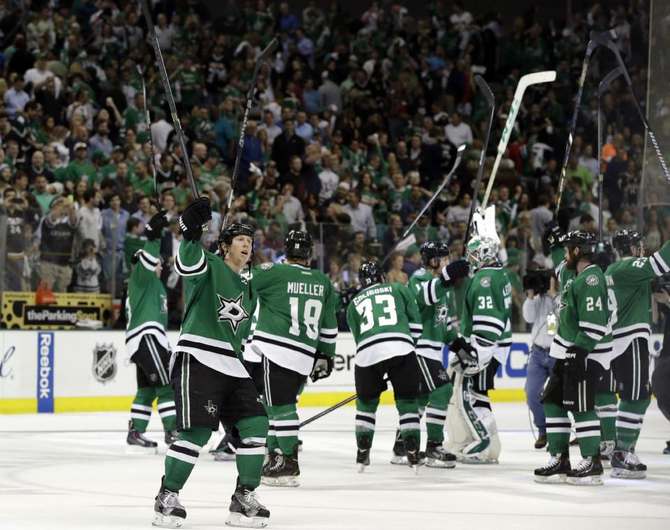 Dallas Stars' Cody Eakin (20) and the rest of the time lift their sticks as they acknowledge cheers from fans following a 4-2 win in Game 4 of a first-round NHL hockey Stanley Cup playoff series against the Anaheim Ducks, Wednesday, April 23, 2014, in Dallas. (AP Photo/Tony Gutierrez)