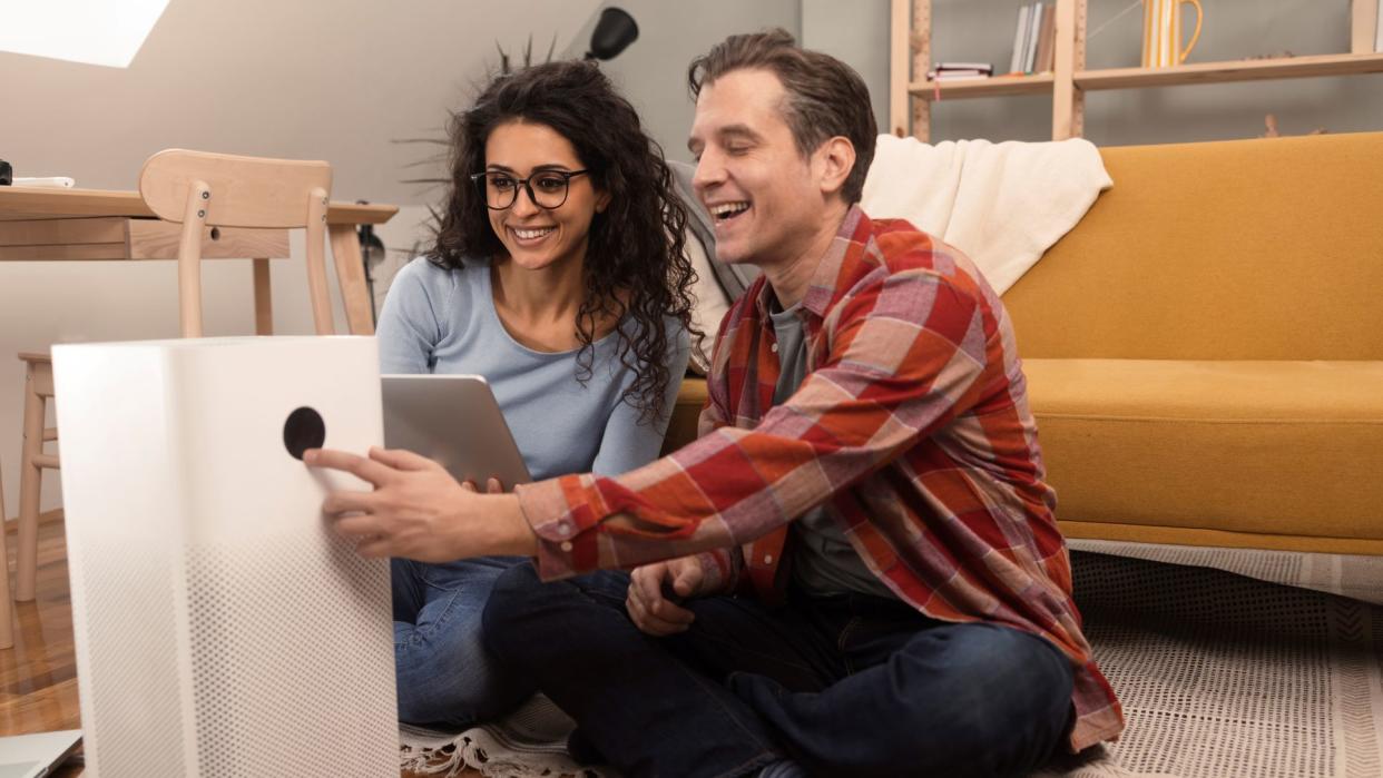  Should you buy an air purifier: Image shows Happy couple use air purifier 