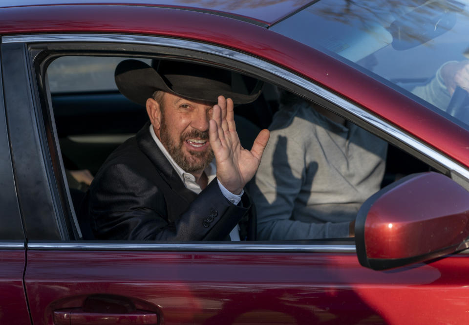 Otero County Commissioner Couy Griffin waves from a car as he leaves federal court in Washington, Monday, March. 21, 2022. Griffin is charged with illegally entering Capitol grounds the day a pro-Trump mob disrupted certification of Joe Biden's presidential election victory on Jan. 6, 2021. (AP Photo/Gemunu Amarasinghe)