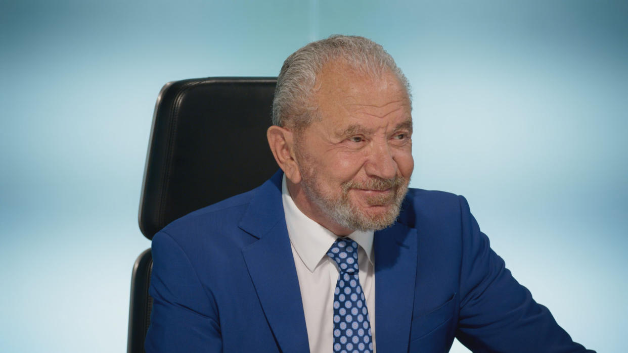 Lord Sugar smiling in the boardroom on The Apprentice