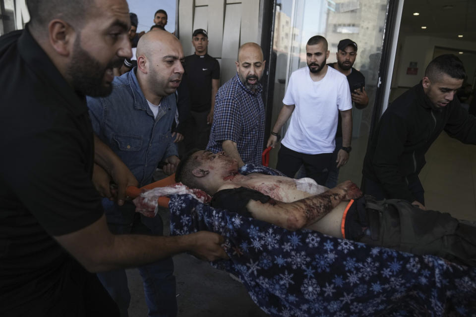 An injured Palestinian is carried into a hospital during an Israeli military raid in the Jenin refugee camp, a militant stronghold in the occupied West Bank, Monday, July 3, 2023. Israeli drones struck targets in the area early Monday and hundreds of troops were deployed. Palestinian health officials said at least five Palestinians were killed. (AP Photo/Nasser Nasser)