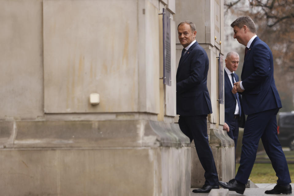 The new Polish Prime Minister Donald Tusk, left, and Jan Grabiec, chief of staff, arrive at the Prime Minister's office in Warsaw, Poland, Wednesday, Dec. 13, 2023. (AP Photo/Michal Dyjuk)