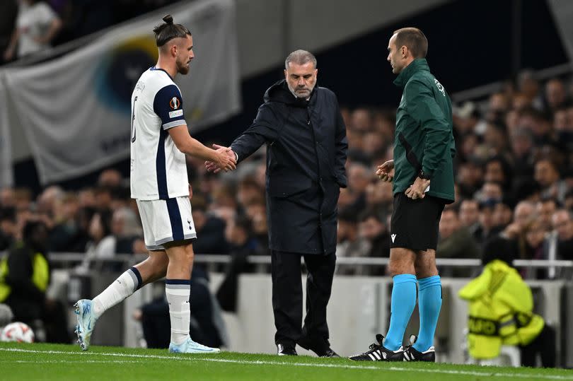 Radu Dragusin shakes hands with Ange Postecoglou after receiving a red card during the Europa League match between Tottenham Hotspur and Qarabag