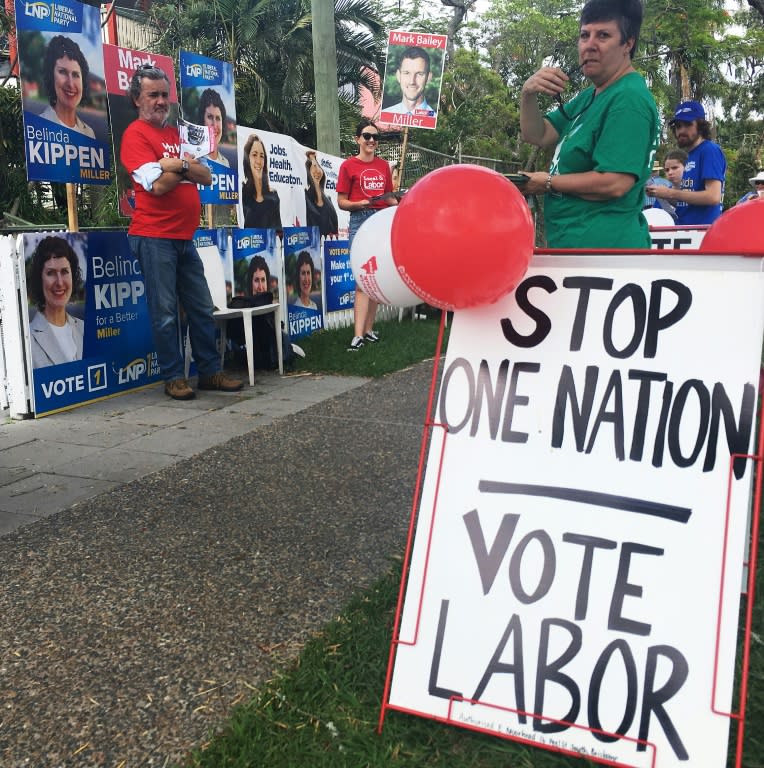 Voters stand by a "stop One Nation - vote Labor" sign in Graceville, near Brisbane on November 25, 2017