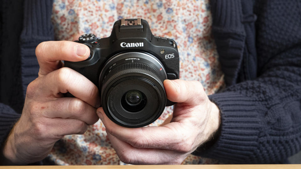 Canon EOS R100 camera in the hand