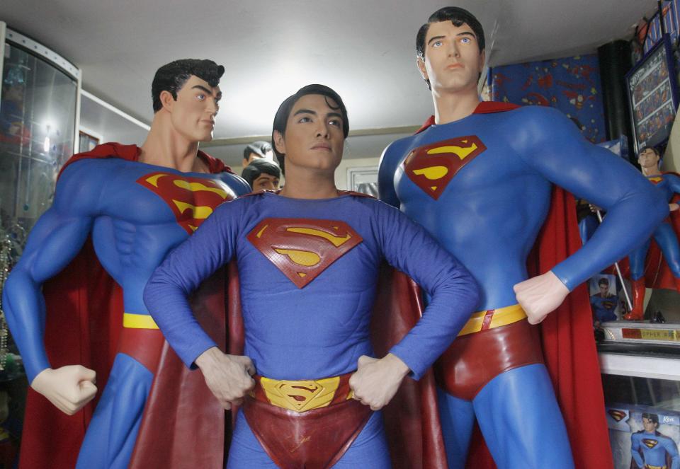 Herbert Chavez poses with his life-sized Superman statues inside his house in Calamba Laguna, south of Manila October 12, 2011. In his idolization of the superhero, Chavez, a self-professed "pageant trainer" who owns two costume stores, has undergone a series of cosmetic surgeries for his nose, cheeks, lips and chin down to his thighs and even his skin color to look more like the "Man of Steel". The final result bears little resemblance to his old self. REUTERS/Cheryl Ravelo (PHILIPPINES - Tags: SOCIETY TPX IMAGES OF THE DAY)