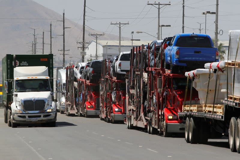 Carrier trailers transport Toyota vehicles for delivery while queuing at the border for customs control to cross into the U.S., at the Otay border crossing in Tijuana