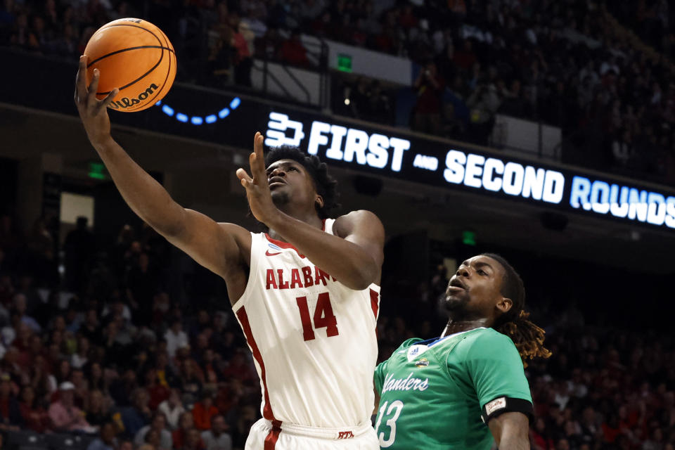 Alabama center Charles Bediako (14) lays in a basket as Texas A&M Corpus Christi forward De'Lazarus Keys (13) defends in the first half of a first-round college basketball game in the NCAA Tournament in Birmingham, Ala., Thursday, March 16, 2023. (AP Photo/Butch Dill)