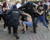 Police try to detain protesters during a mass rally following presidential elections in Minsk, Belarus, Monday, Aug. 10, 2020. Thousands of people have protested in Belarus for a second straight night after official results from weekend elections gave an overwhelming victory to authoritarian President Alexander Lukashenko, extending his 26-year rule. A heavy police contingent blocked central squares and avenues, moving quickly to disperse protesters and detained dozens. (AP Photo/Sergei Grits)