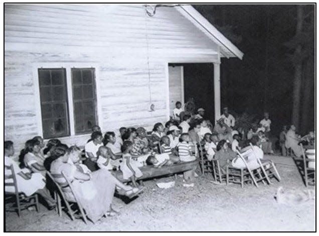 A young Fred Glenn is the boy in a striped shirt sitting on a bench outside Baltimore Village School while watching a movie.